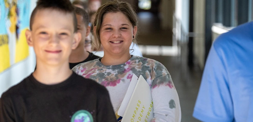 Smiling students lined up in a school hallway